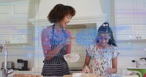 Mother and daughter baking together laughing and learning with augmented reality overlay