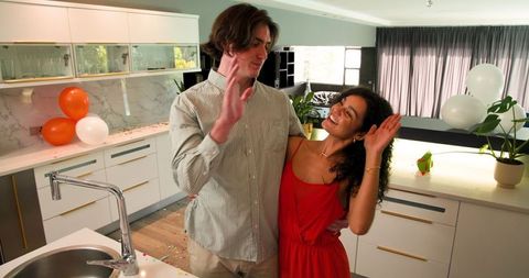 Couple Cleaning Up After Kitchen Party Celebration