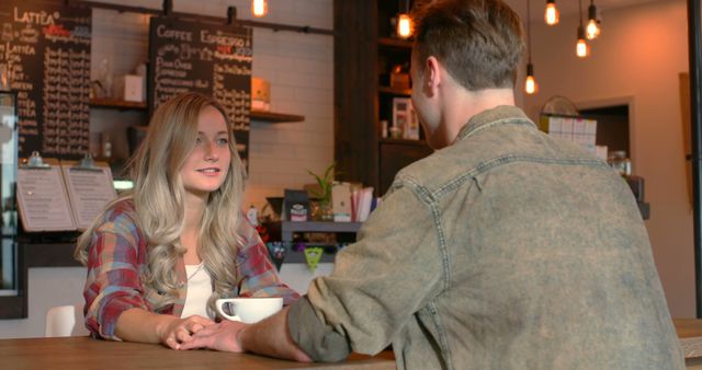 Young couple interacting with each other in cafe. Couple having coffee in cafe 4k