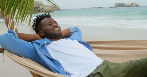 Relaxed Young Man Smiling on Tropical Beach Hammock
