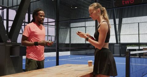Athletes Using Smartphones Before Padel Tennis Match at Indoor Court