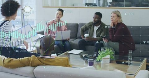 Diverse team brainstorming in office lounge with laptops and financial analytics overlay