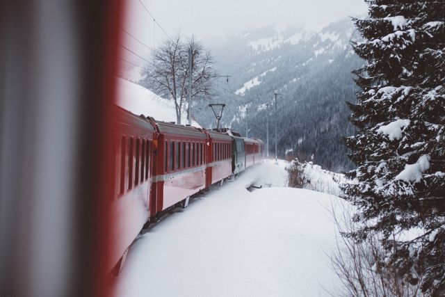 Train traveling through snowy mountains offers scenic views, perfect for winter travel promotions, transportation concepts, adventure blogs, or outdoor travel magazines. Ideal for using in travel agency websites, winter season advertisements or social media stories showcasing serene and picturesque winter landscapes.
