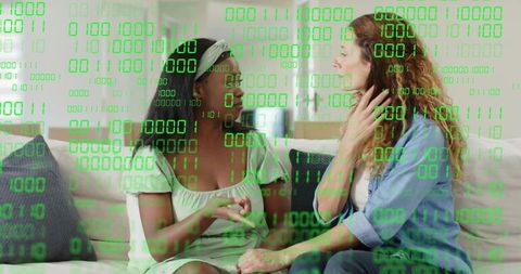 Two Women Holding Hands and Talking on Couch with Green Binary Code Overlay for Empathy and Tech