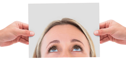 Hands Holding Paper with Woman's Eyes on Transparent Surface