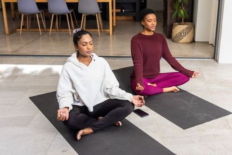 Diverse women meditating on patio mats practicing mindfulness and gentle yoga for wellness