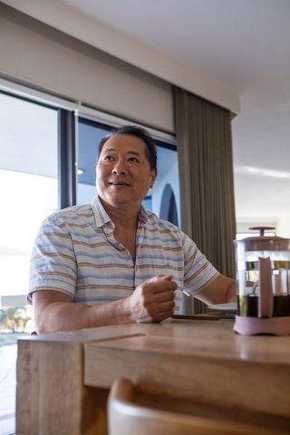 Asian man enjoying peaceful morning with coffee at home