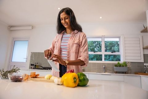 Indian Woman Chopping Vegetables in Modern Kitchen