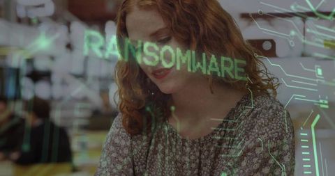 Young woman monitoring ransomware alert on futuristic cybersecurity interface at workstation