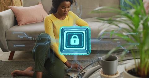 Black woman working from home using laptop with holographic lock cybersecurity concept