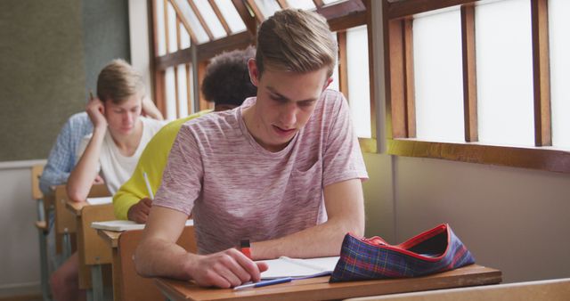 Young Students Focused on Writing During Classroom Exam - Download Free Stock Images Pikwizard.com