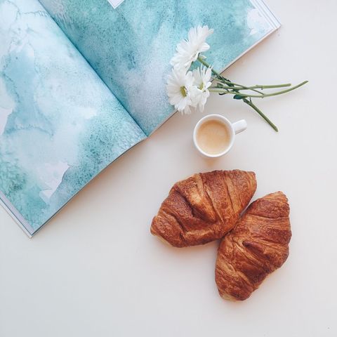 Morning coffee with croissants and magazine overhead view