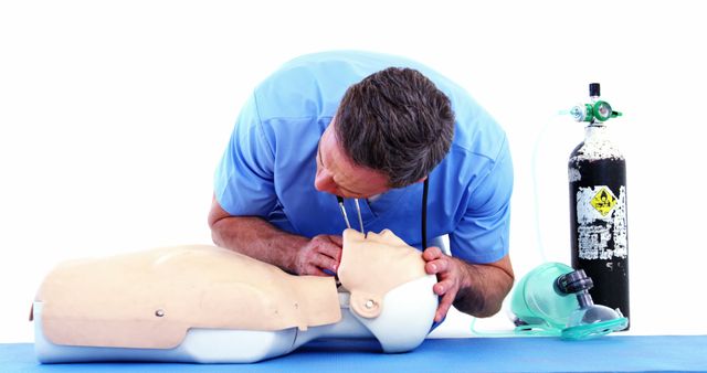 Healthcare professional performing CPR on mannequin. Oxygen tank visible nearby. Useful for depicting medical training, instructional materials on emergency procedures, and healthcare education resources.