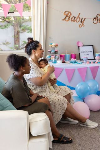 Two friends celebrating newborn baby at cozy baby shower