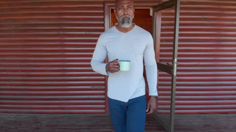 Man Enjoying Tea on Countryside Cabin Veranda