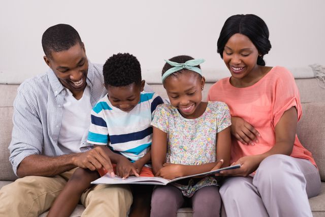 Smiling family reading magazine while sitting on sofa at home