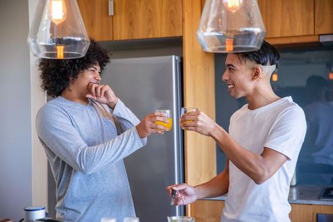 Diverse Friends Clinking Glasses in Modern Kitchen Together