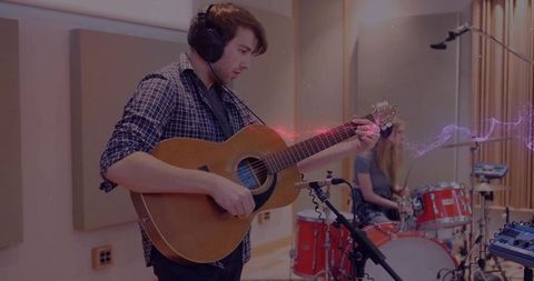 Guitarist and drummer recording in professional music studio