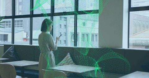 Woman Holding Phone Looking Out Cafe Lounge Window