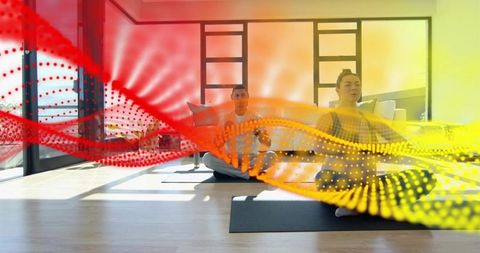 Sunlit yoga duo meditating in modern studio with vivid abstract energy wave overlays