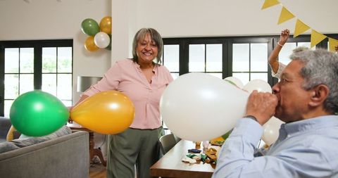 Senior Friends Prepping Birthday Celebration with Balloons