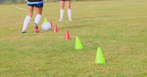 Girls Practicing Soccer on Green Field with Cones