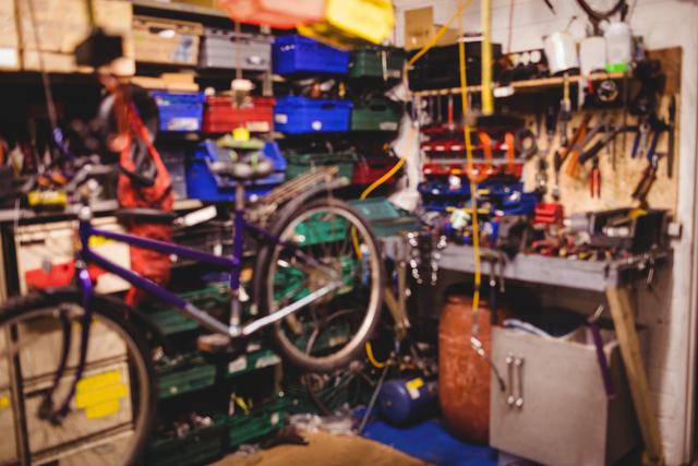 Image depicts a busy workshop filled with various tools and equipment. A bicycle is being repaired, indicating a focus on maintenance and DIY projects. Ideal for illustrating themes of mechanics, repair work, and organized workspaces. Suitable for use in articles, blogs, or advertisements related to bicycle repair, DIY projects, and mechanical work.