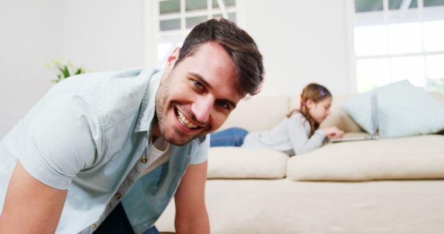 Man Smiling with Child Using Laptop on Sofa in Background - Download Free Stock Images Pikwizard.com