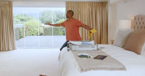 Couple packing suitcase, enjoying vacation planning at home