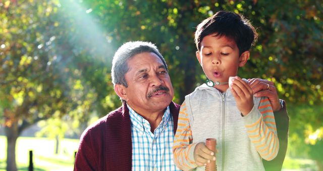 Multigenerational family spending quality time in park, grandfather and grandson, reinforcing family bonds and traditions, ideal for family, lifestyle, and generational stories in advertising.