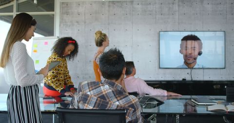 Diverse team holding video conference call in modern office