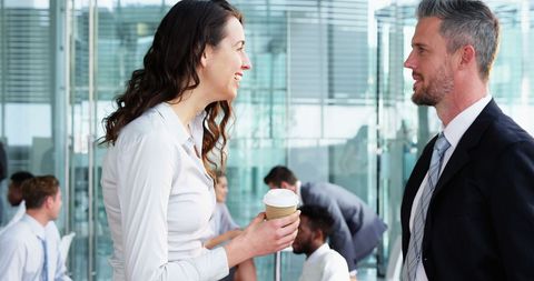 Professionals Discussing Over Coffee Break in Modern Office Setting