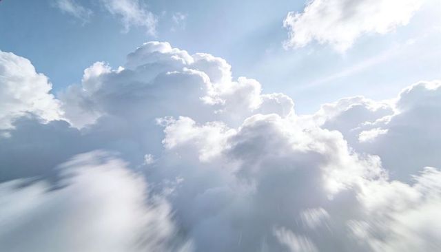 Sunlit Cumulus Cloudscape Soaring Through Blue Sky With Radiant Sun Rays