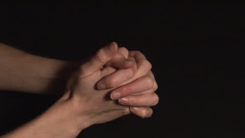 Hands Praying on Dark Background in Reverent Pose