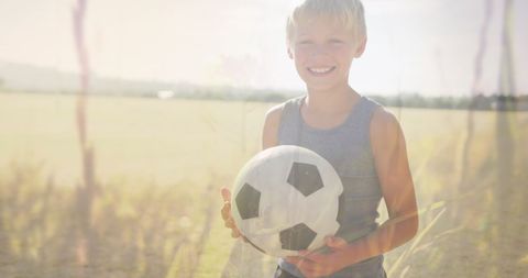 Joyful Boy Holding Soccer Ball in Sunny Field - Download Free Stock Images Pikwizard.com