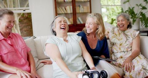Senior Friends Laughing Together in Cozy Living Room