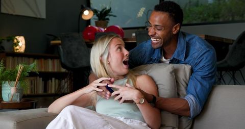 Happy Couple Embracing During Heartfelt Proposal at Home