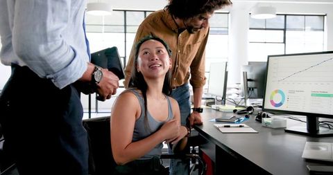 Happy Colleagues Collaborating Around Office Computer