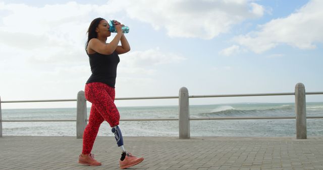 Side view of disabled woman drinking water on promenade. Disabled woman walking on promenade 4k