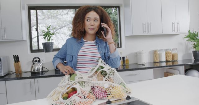 Woman Talking on Phone in Modern Kitchen with Grocery Bags - Download Free Stock Images Pikwizard.com