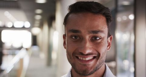 Confident Male Professional Smiling in Modern Office Corridor