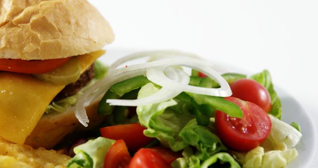 Close-up of a fresh cheeseburger served with a side salad and chips. Ideal for use in advertisements, menus, food blogs, and nutritional content. Suggesting a balanced meal option combining indulgence with healthiness.
