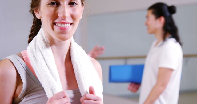 Portrait of woman standing with towel in fitness studio 4k