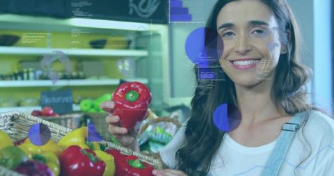 Smiling shopper holding red bell pepper with digital data overlay in produce aisle