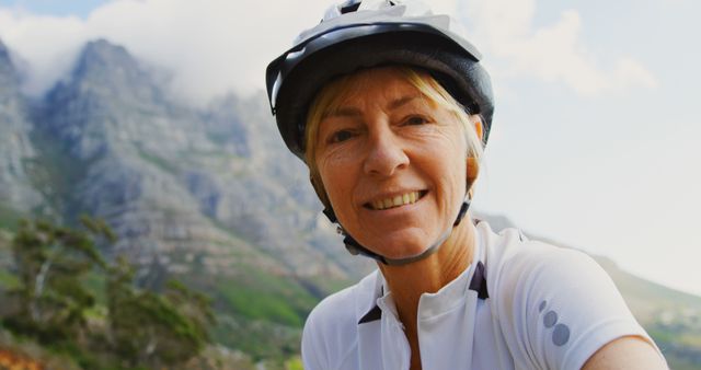 Senior Woman Cycling in Mountain Area Smiling at Camera - Download Free Stock Images Pikwizard.com