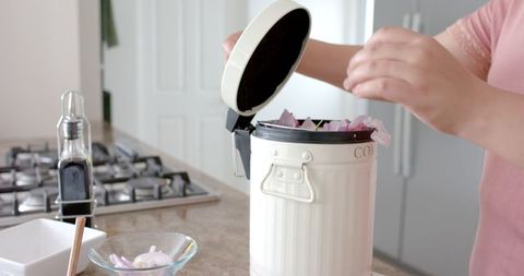 Woman Composting Vegetable Waste in Kitchen for Ecological Living