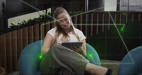 Woman engaging with tablet in modern office lounge