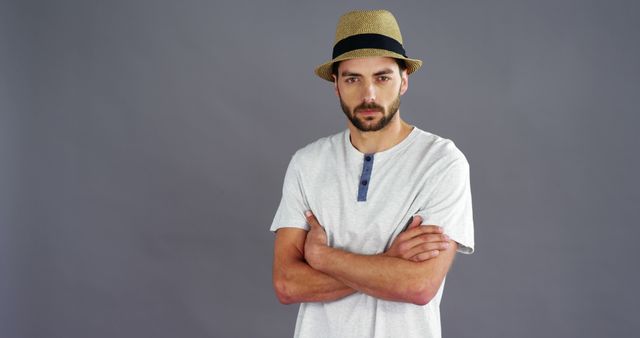 Confident Young Man Posing in Hat Against Gray Background - Download Free Stock Images Pikwizard.com