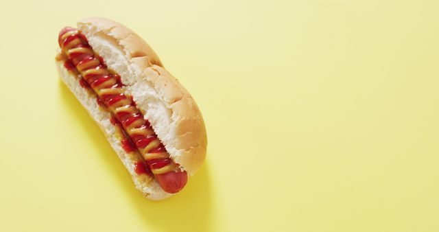 Image of hot dog with mustard and ketchup on a yellow surface. food, cuisine and catering ingredients.