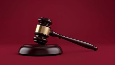 Judge's gavel with sound block on red background